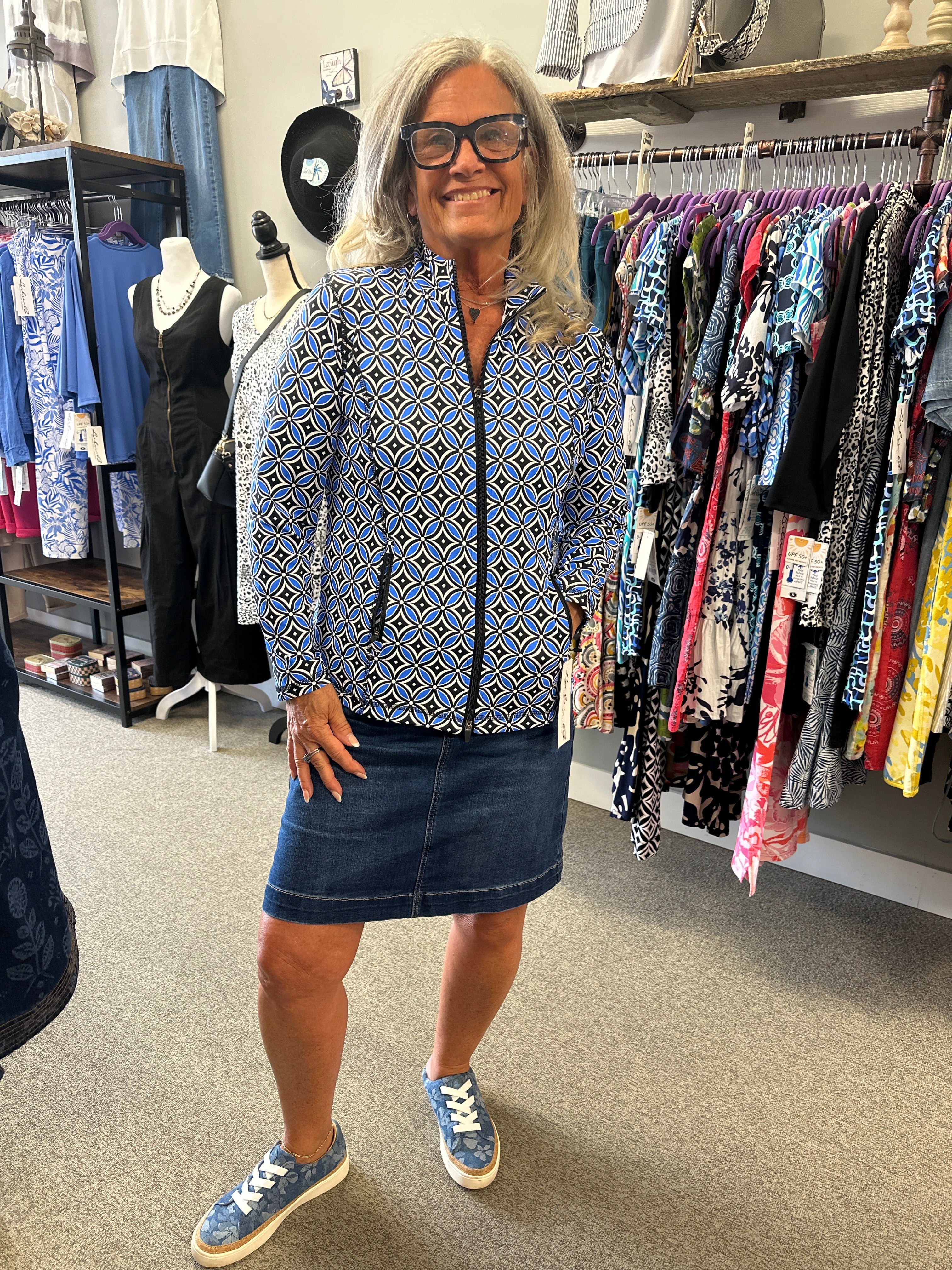 Person wearing a patterned shirt and denim shorts in a store setting
