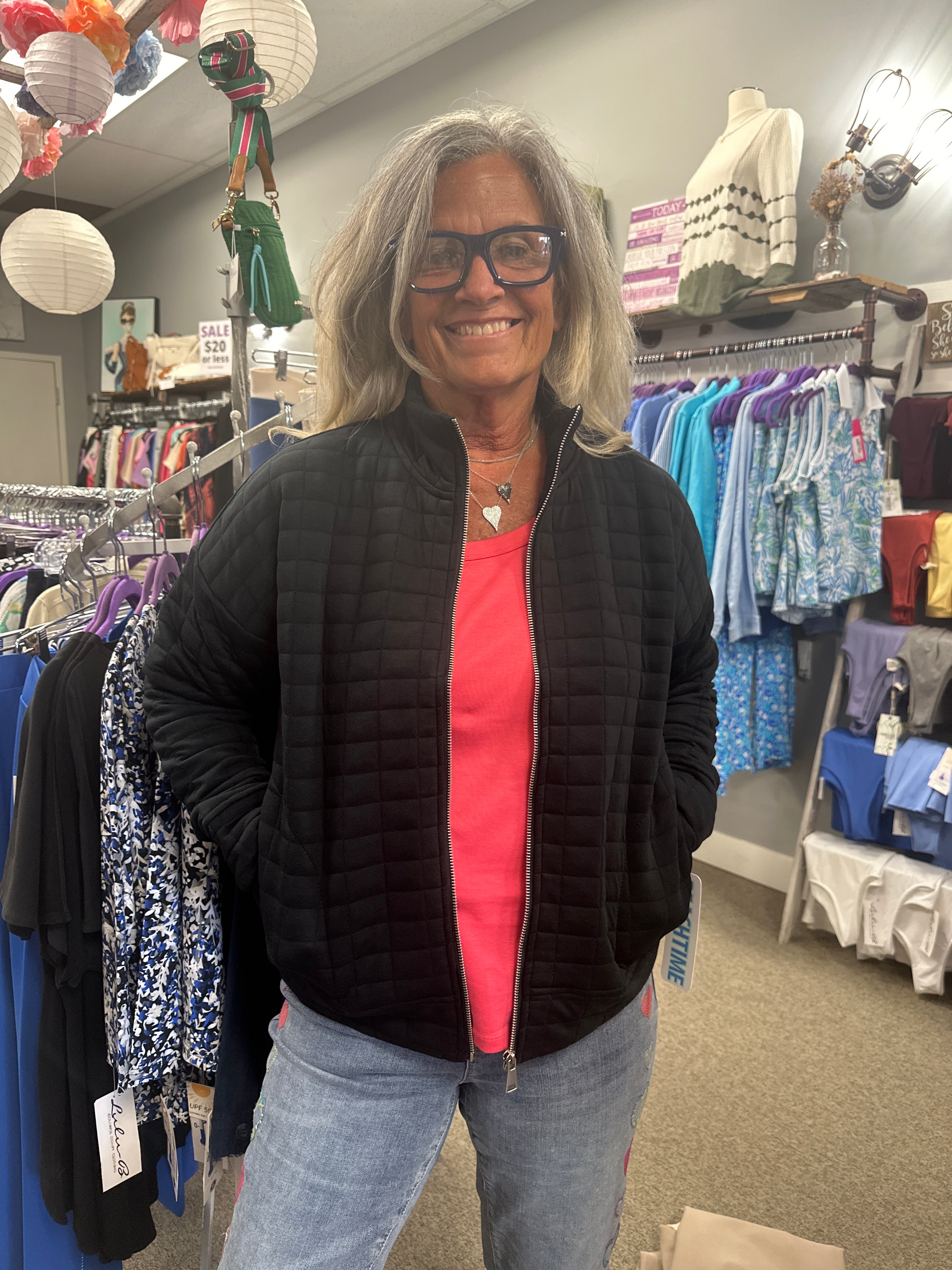 Person wearing a black vest with a red interior in a store setting