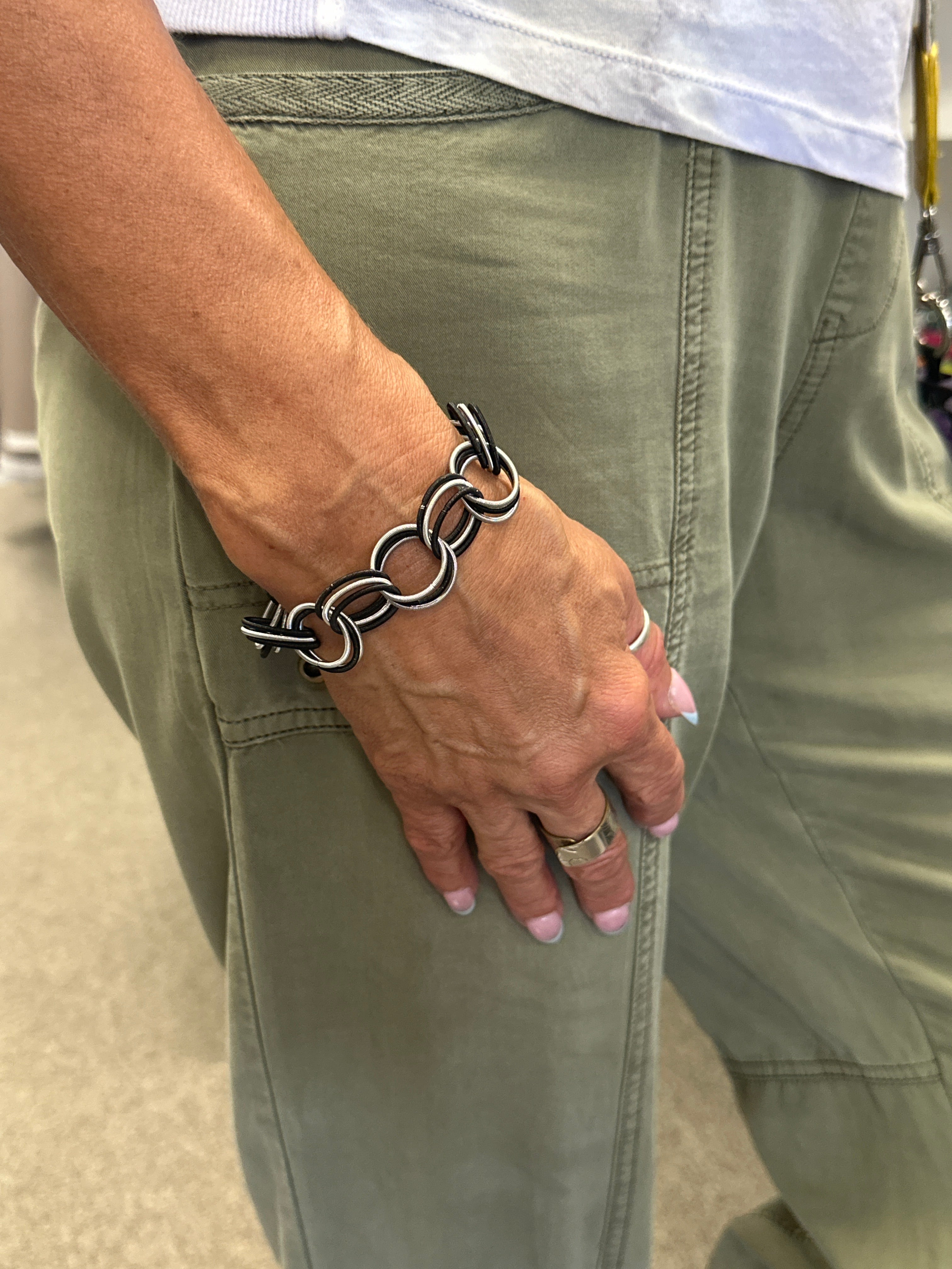 Person wearing a chain bracelet on a light-colored background